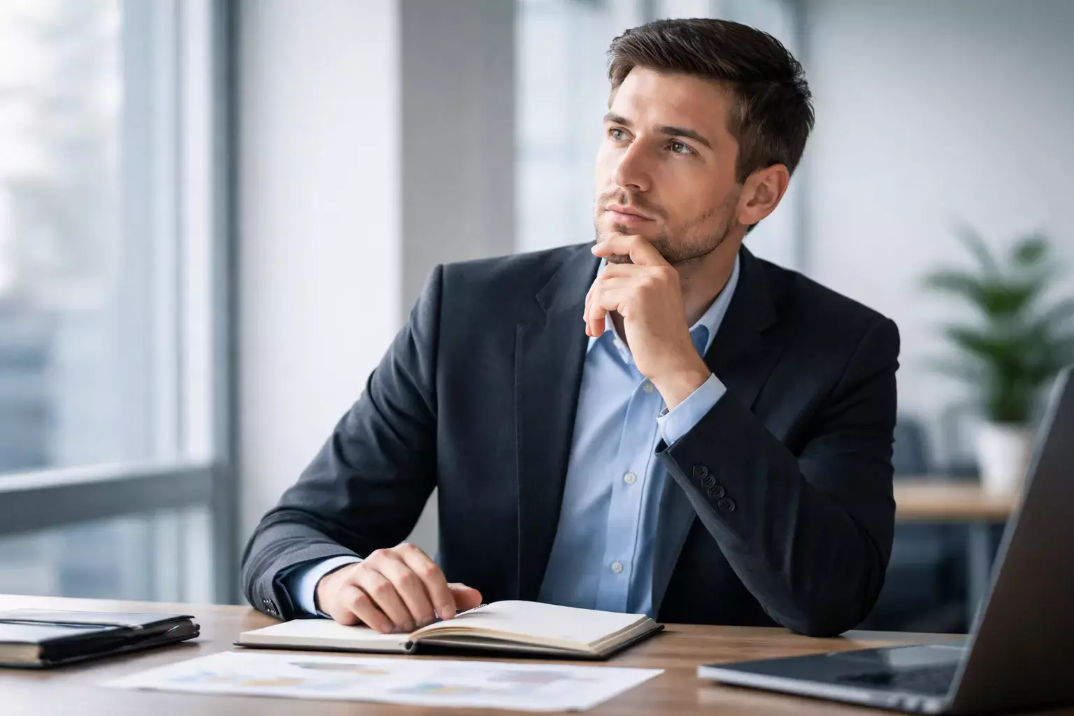 Nachdenkliche Person trifft eine Entscheidung am Schreibtisch